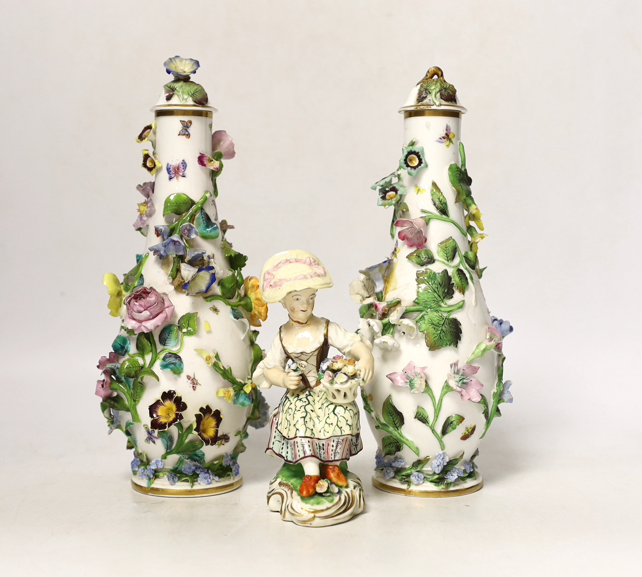 A pair of Minton flower encrusted bottle vases and covers, c.1835, and a Minton seated figure of a flower girl, c.1830-5, pseudo Meissen mark, bottle vases and covers, 22.5cm high